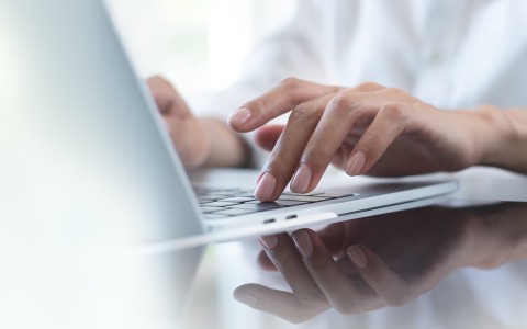 Person recherchiert am Laptop